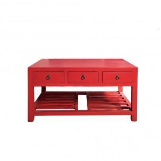 Mesa baja con revistero rojo.